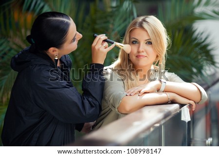 Makeup master doing visage to young beautiful model