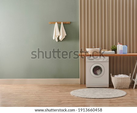 Washing machine in the laundry room style, interior concept, dirty clothes decor coffee table with vase of plant. Wooden bench, sink and towel.