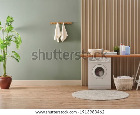 Washing machine in the laundry room style, interior concept, dirty clothes decor coffee table with vase of plant. Wooden bench, sink and towel.