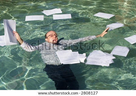 Image of a business man drowning in paperwork.