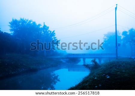 Small bridge, small canal and mist background in Thai country, Thailand
