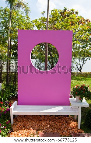 White bench with pink screen in garden, Thailand.