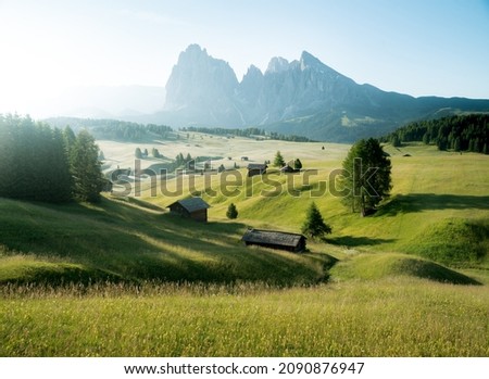 Scenic panoramic view of idyllic Dolomites mountain scenery with traditional wooden mountain huts at Alpe di Siusi in beautiful morning light at sunrise in spring, South Tyrol, northern Italy Stok fotoğraf © 