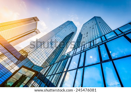 Bottom view of modern skyscrapers in business district at sunset with lens flare filter effect