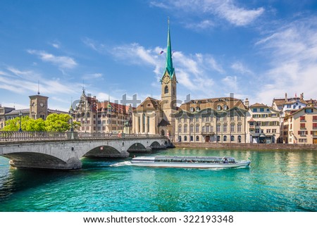 Panoramic view of the historic city center of Zurich with famous Fraumunster Church and excursion boat on river Limmat on a sunny day with blue sky, Canton of Zurich, Switzerland