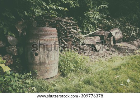 Whiskey Barrel and Woodpile Rural. Rural scene with an old whiskey barrel and piles of firewood.