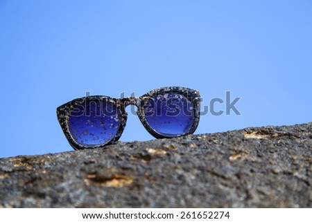 plastic sunglasses after prolonged exposure to sun and sea, lying lonely on the stone