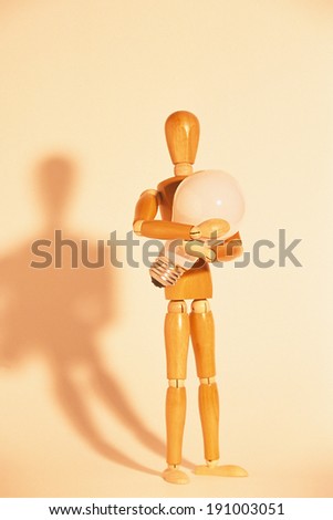 Artists mannequin holding a lightbulb