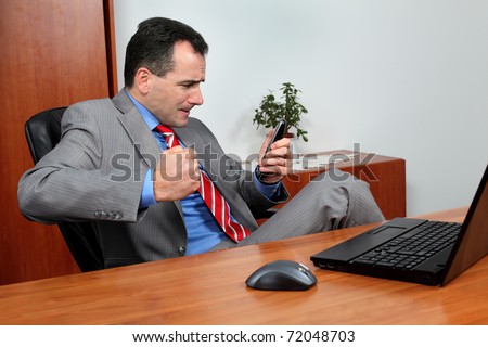 Angry businessman in his office talking on the phone.