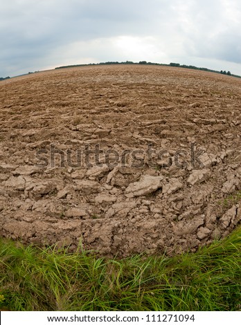 Plowed soil of an agricultural field, horizon line bending