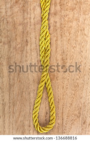Twisted gold rope on a brown wooden background