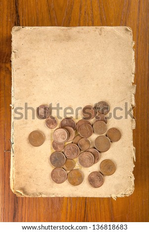 Copper euro cents coins on old softcover book