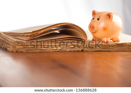 Piggy bank on the opened old book