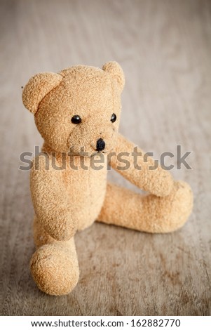 Brown toy bear on a wooden background