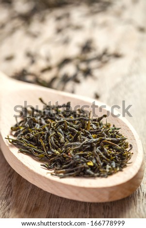 Wooden spoon with green tea herbs.Selective focus, shallow depth of field