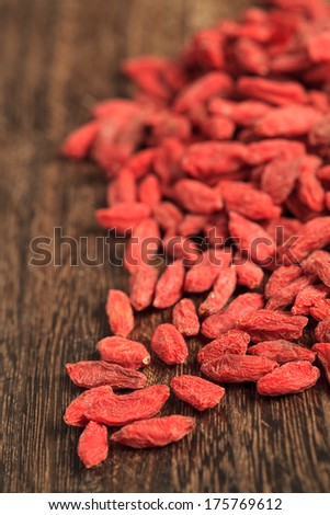 Goji berries closeup on brown wooden table. Shallow depth o field