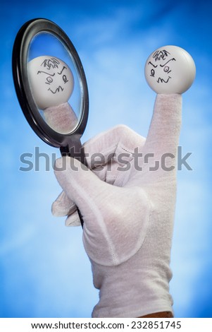 White finger puppet looking at the round mirror