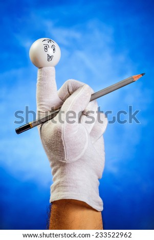 Happy finger puppet with sharp pencil over blue background