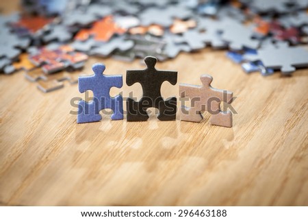 Three color jigsaw puzzle pieces on table. Shallow depth of field