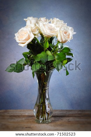 White Roses on a rustic old vintage table with blue background and copy space