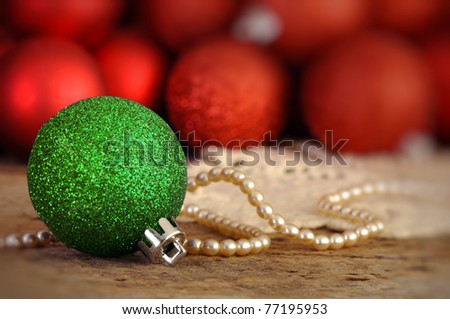 Red and green Christmas balls on an old vintage table with pearls