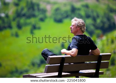 man on bench in forest