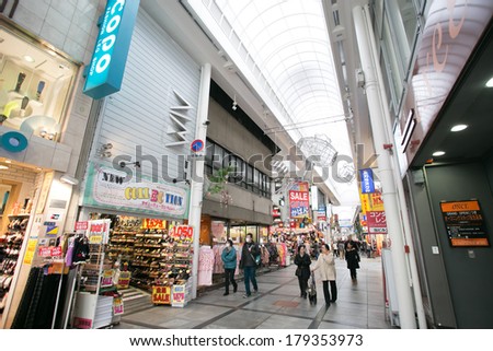 Osaka, Japan - January 20, 2014: Shinsaibashi-Suji a shopping arcade in the Namba area of Osaka, Japan. People can be seen walking in the arcade and waiting to cross the road.