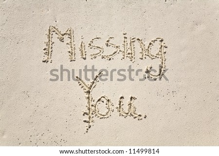 Missing you written in the sand