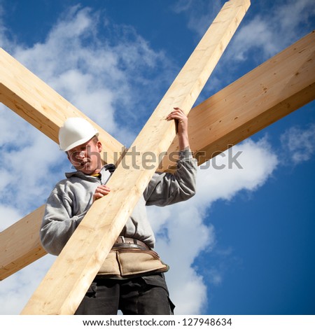 builder at work with wooden  roof construction