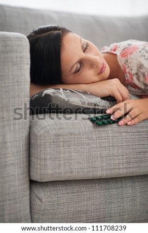 Young woman sleeping with pack of tablets