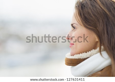Young woman looking into distance in winter outdoors.