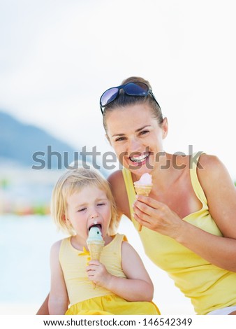 Smiling mother and baby eating ice cream