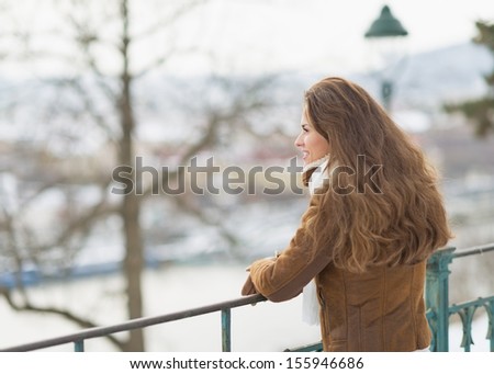 Happy young woman in winter park looking into distance