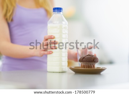 Closeup on young woman with milk and chocolate muffin