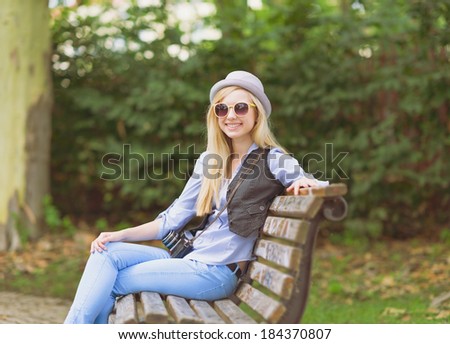 Young hipster sitting on bench in the park