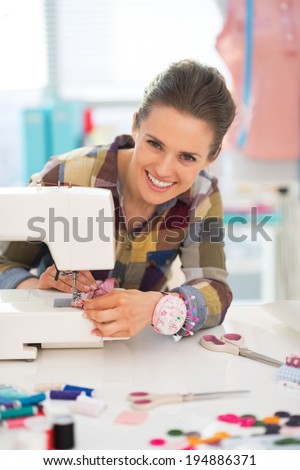 Happy seamstress sewing in studio