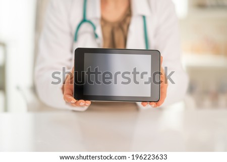 Closeup on medical doctor woman showing tablet pc blank screen
