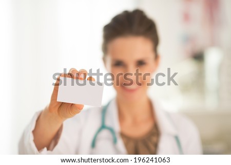 Closeup on happy medical doctor woman showing business card