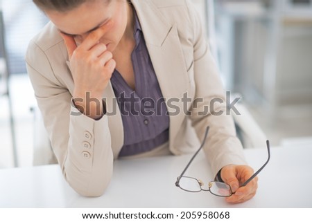 Stressed business woman with eyeglasses in office