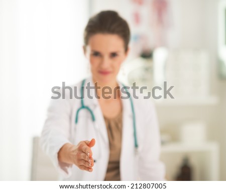 Closeup on doctor woman stretching hand for handshake