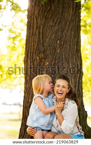 Portrait of happy mother and baby girl having fun in park