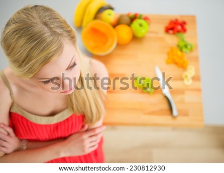 Young woman cutting fruits in kitchen