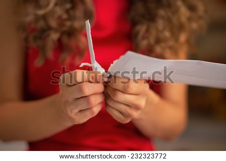 Closeup on young housewife opening envelope