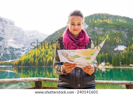 Young woman with map on lake braies in south tyrol, italy