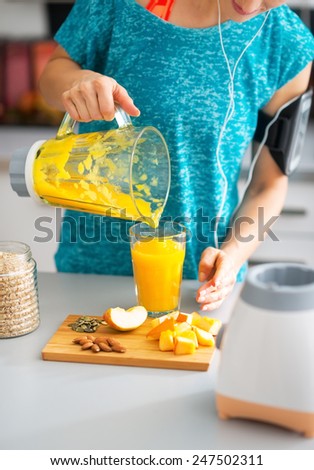 Close-up on fitness young woman pouring pumpkin smoothie in glass