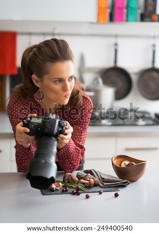 Concerned female food photographer checking photos in camera