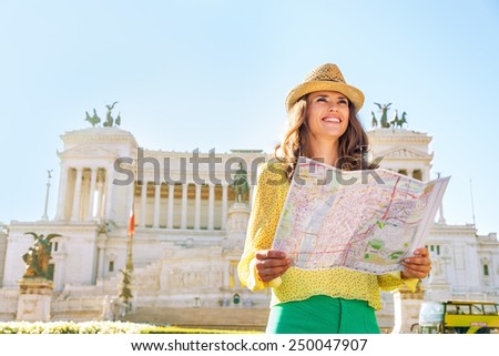 Happy young woman with map on piazza venezia in rome, italy