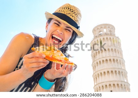 Wait, I can\'t stop laughing long enough to take a bite. Here, a lovely brunette tourist laughs out loud while holding a slice of fresh pizza. In the background, the Leaning Tower of Pisa.