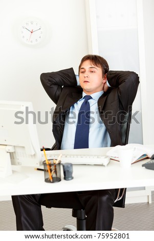 Tired  business man sitting at office desk and looking at computer monitor. Concept - case closed