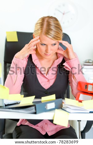 Tired modern business woman sitting at workplace overwhelmed with sticky reminder notes